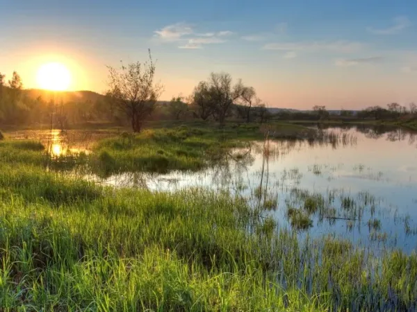 Landschaft mit See vor Sonnenuntergang 